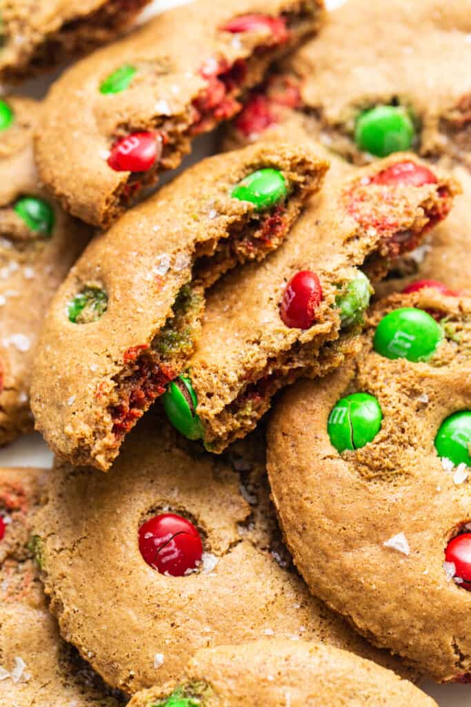 A pile of cookies with m & m's on top.