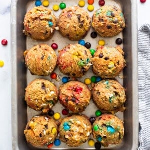 A baking sheet filled with cookies and m&m's.