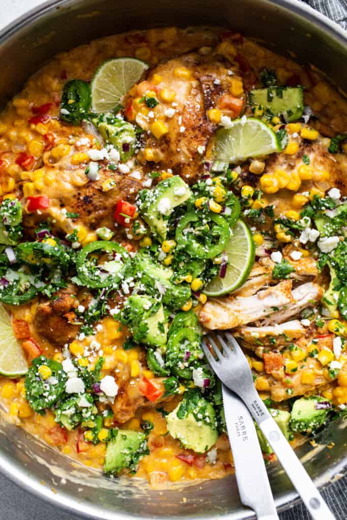 A skillet of chicken, corn and vegetables.