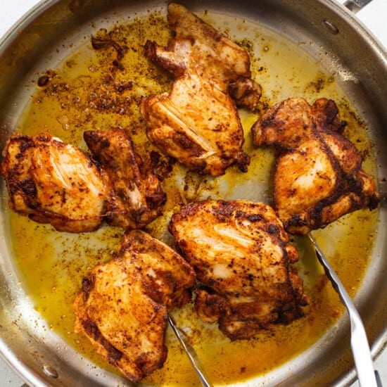 Chicken in a pan with two forks.