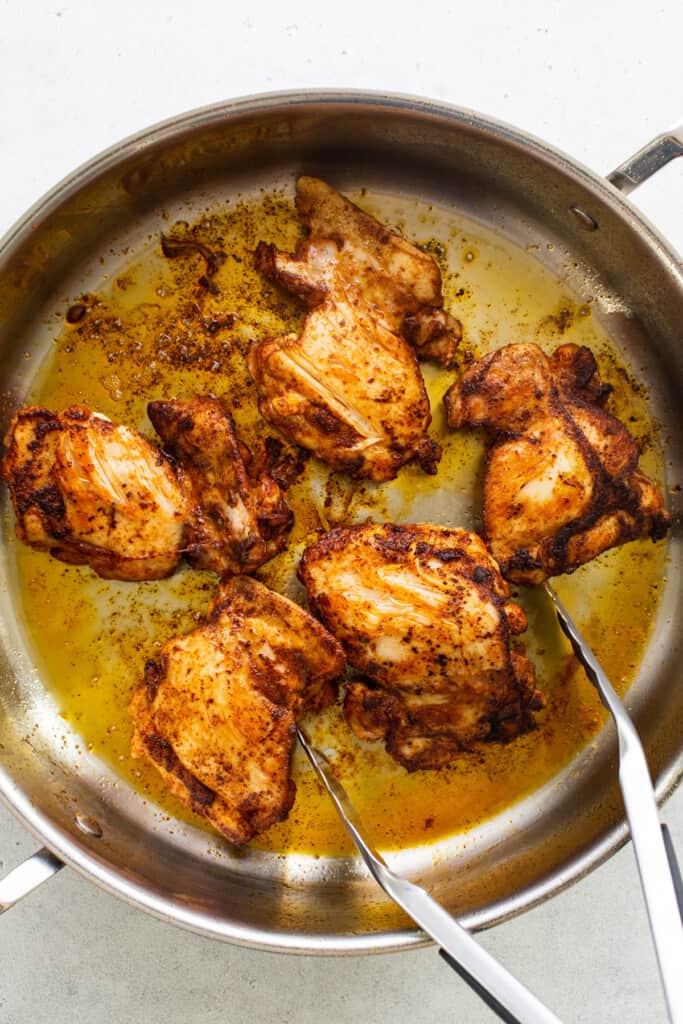 Chicken in a pan with two forks.