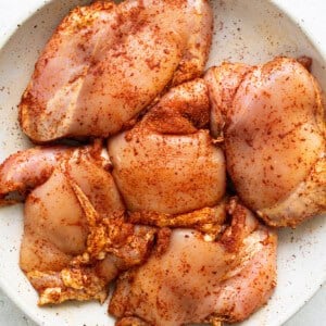 Chicken breasts in a white plate on a white background.