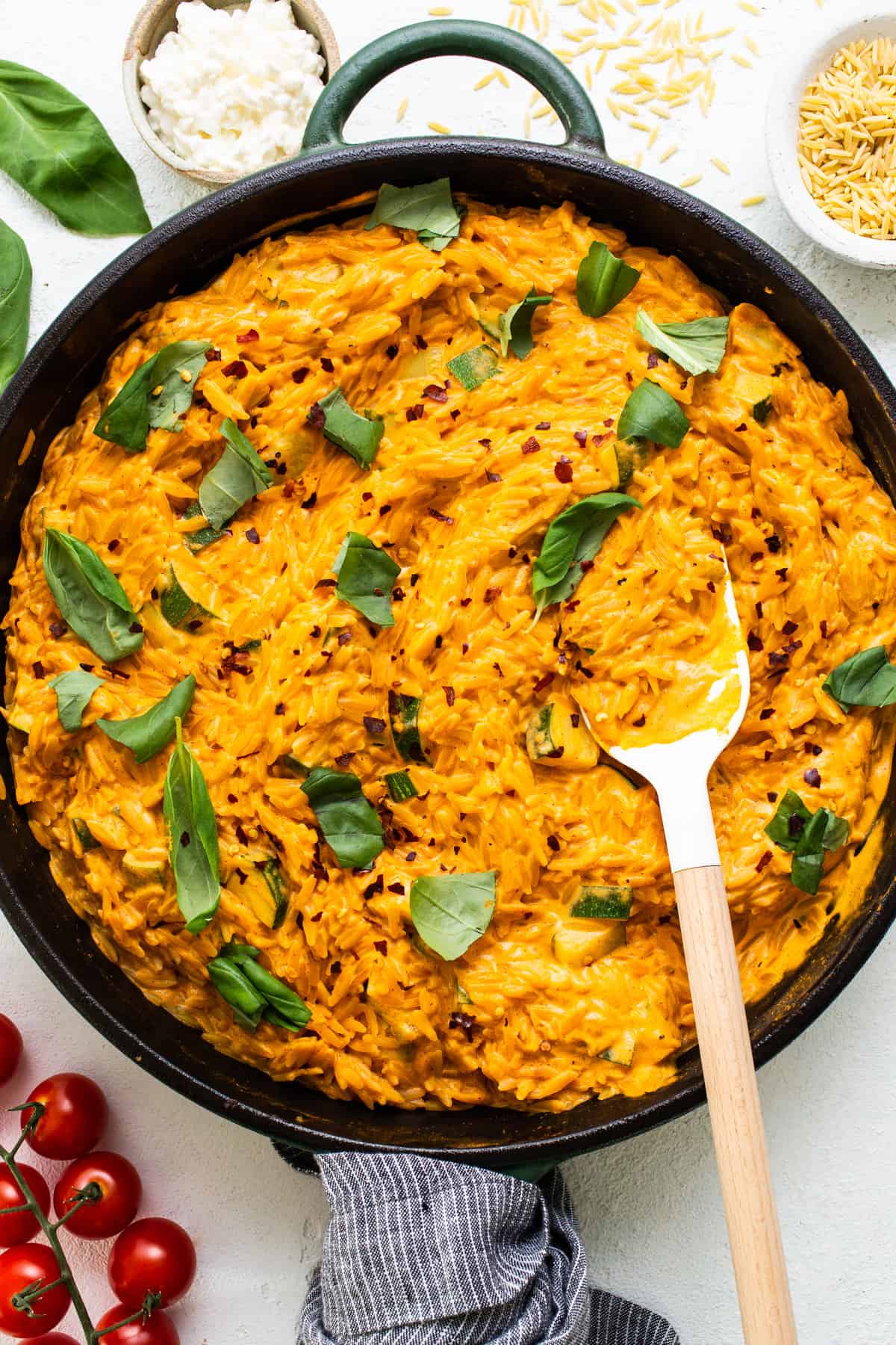 A skillet filled with mashed potatoes, tomatoes and herbs.