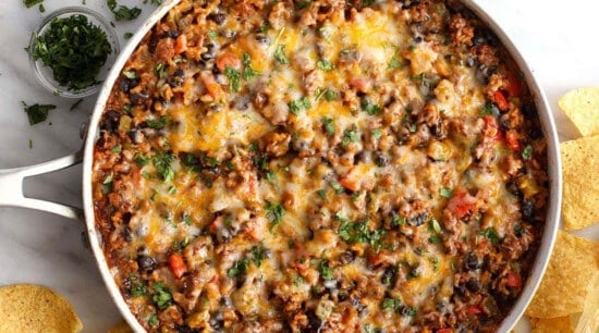 Mexican bean dip in a pan with tortilla chips.