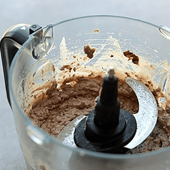 A food processor filled with chocolate batter and Black Bean Breakfast Burritos.