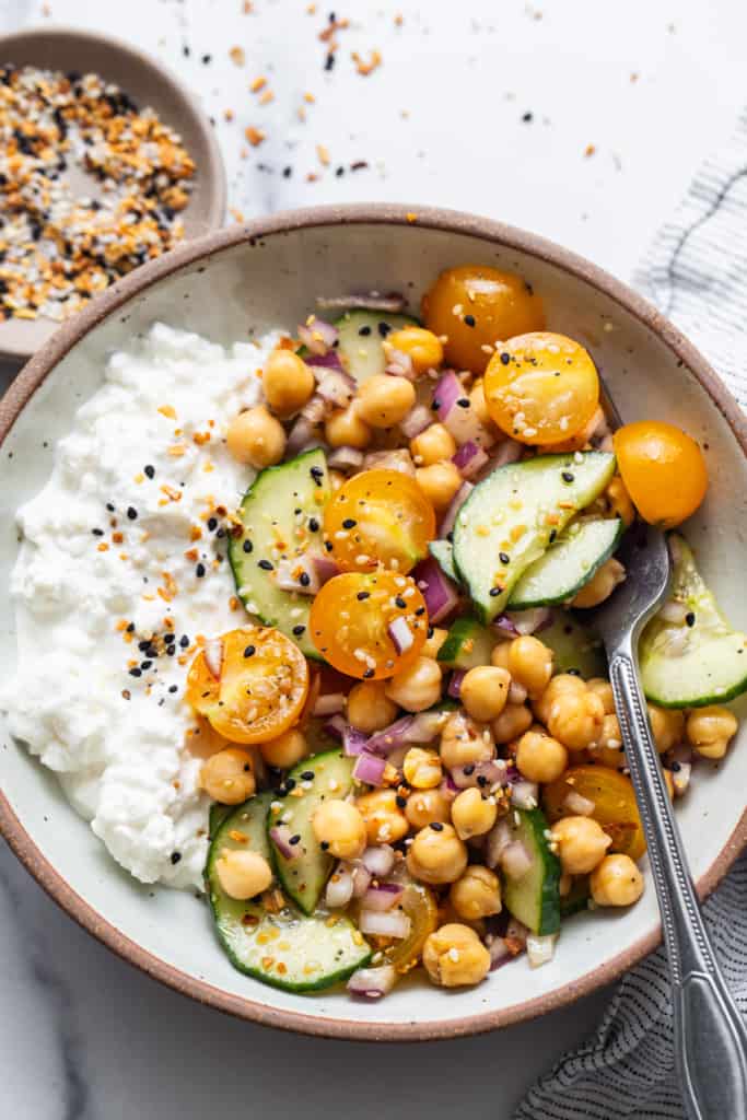 A bowl with chickpeas, cucumber and rice.