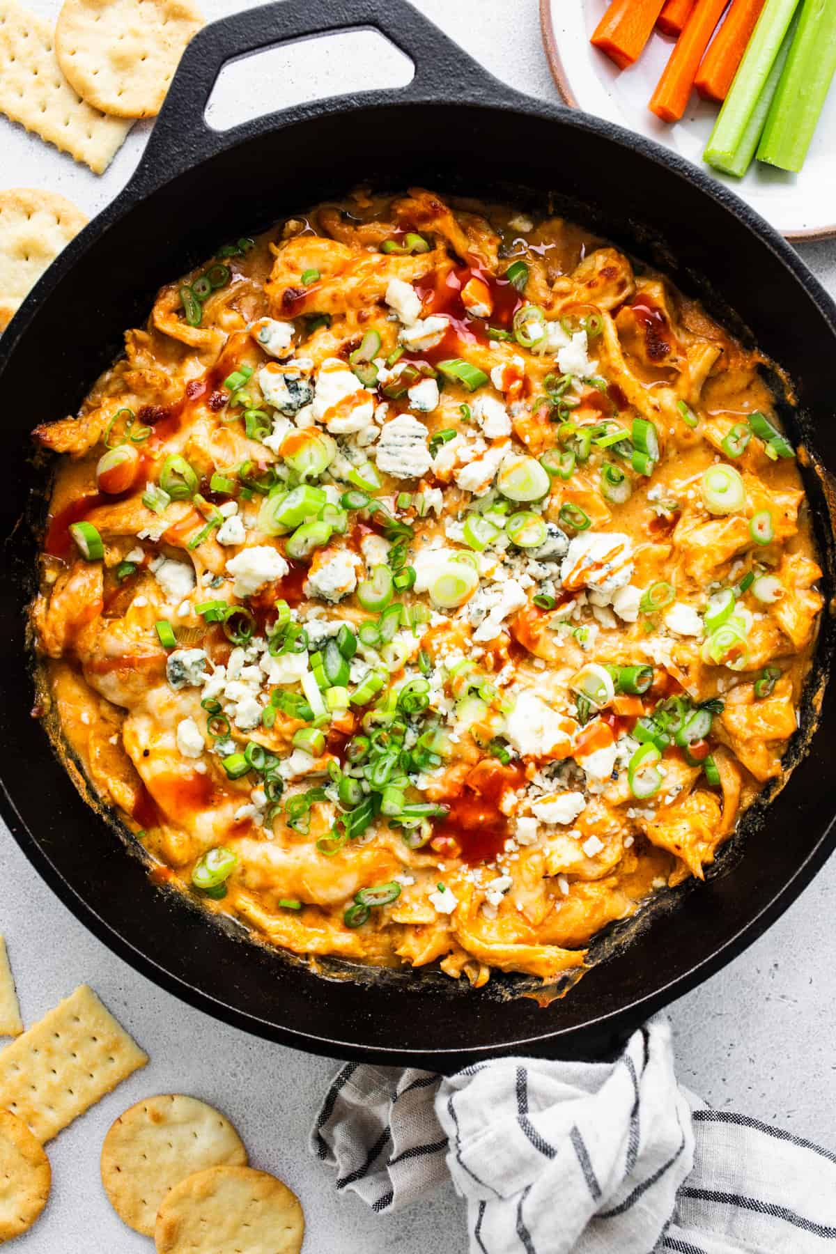 Buffalo chicken dip in a skillet with crackers.