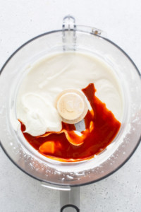 A food processor filled with sauce and whipped cream.