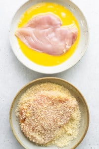 Two bowls with chicken breasts and a bowl of sour cream.