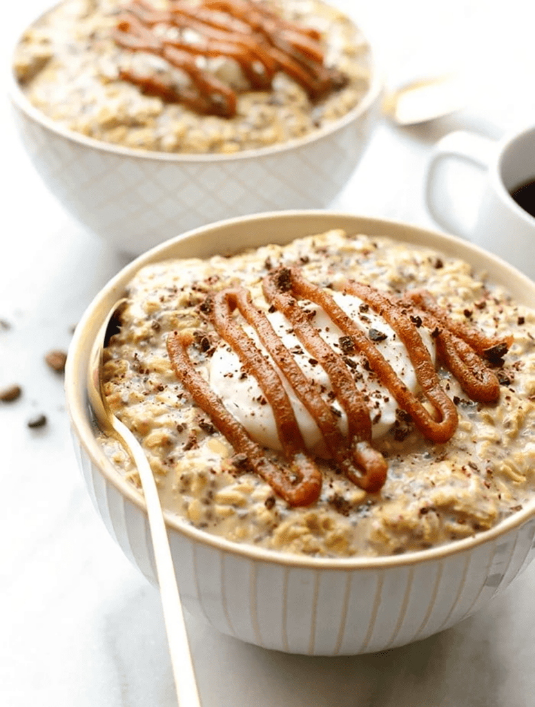Two bowls of Coffee Overnight Oats with caramel sauce and coffee.