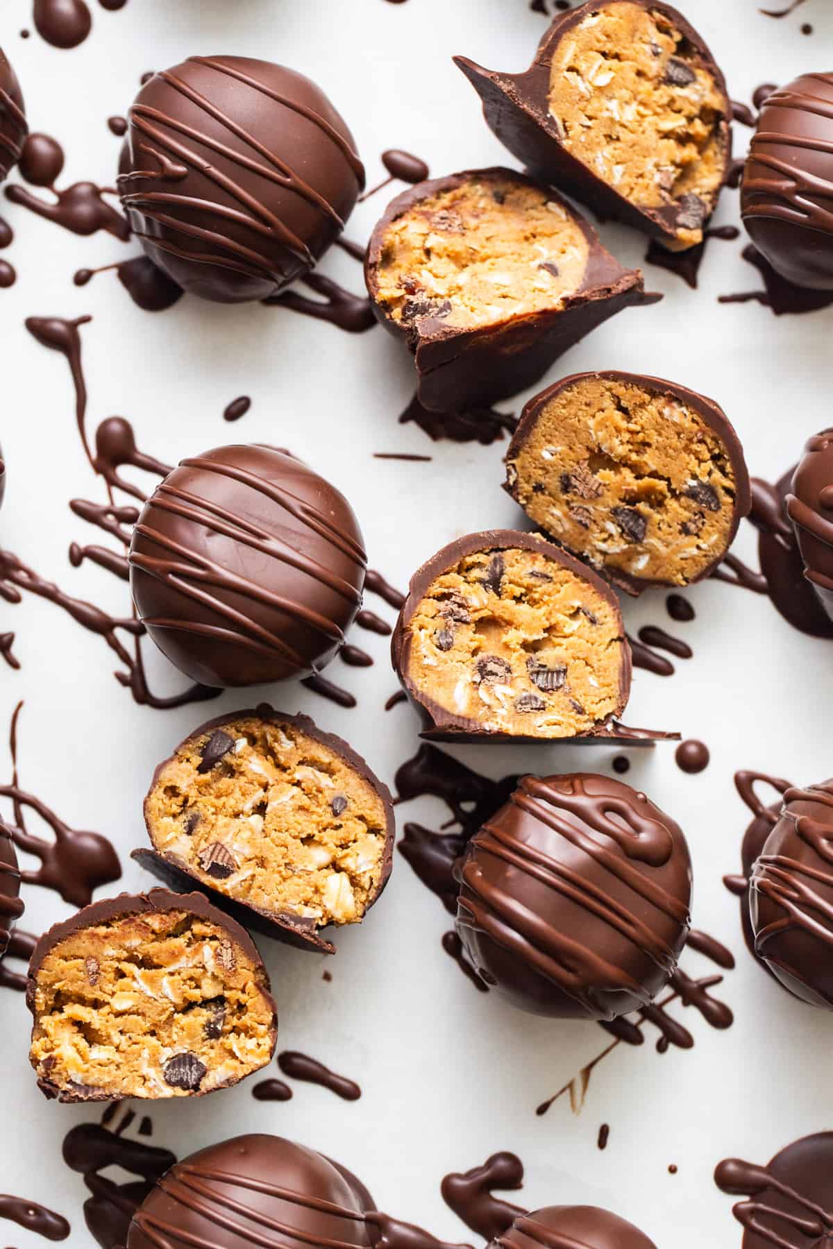 Chocolate covered peanut butter balls on a white surface.