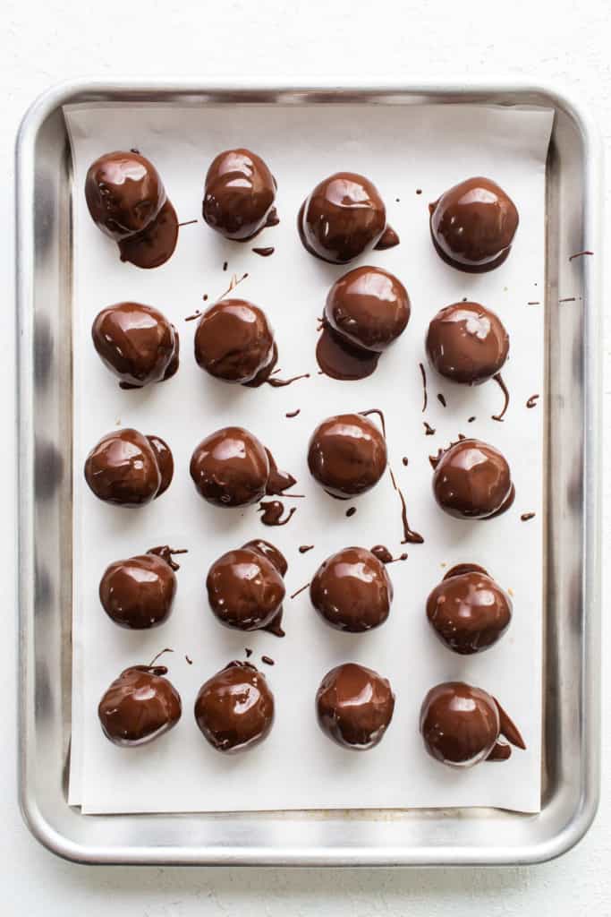 Chocolate covered peanuts on a baking sheet.