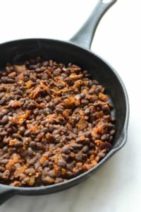 Delicious black beans cooked in a cast iron skillet, perfect for creating mouthwatering black bean breakfast bowls.