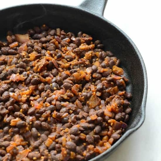 Delicious black beans cooked in a cast iron skillet, perfect for creating mouthwatering black bean breakfast bowls.
