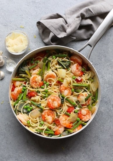 A pan with shrimp scampi and asparagus in it.