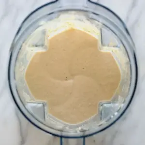 A food processor filled with a mixture of banana protein shake ingredients.