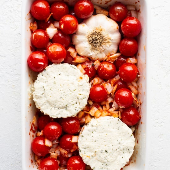 A white baking dish filled with tomatoes and cheese.