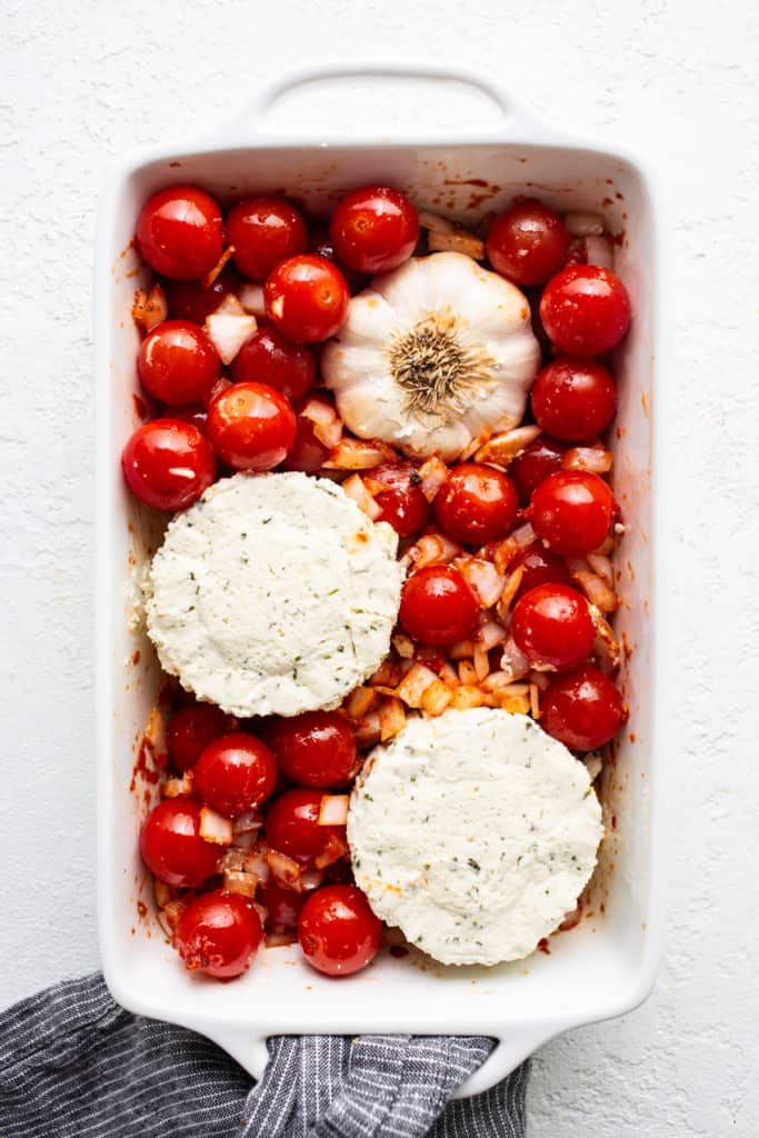 A white baking dish filled with tomatoes and cheese.