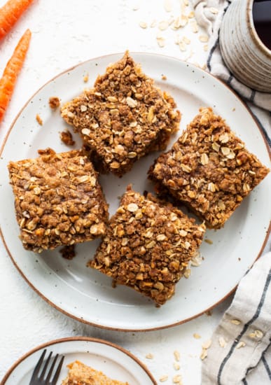 Oat bars on a plate with carrots and a cup of coffee.