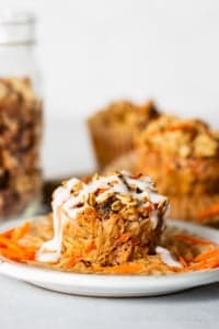 Carrot muffins on a plate with a jar of granola.