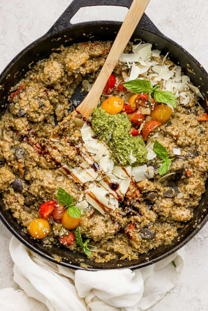A skillet filled with vegetables and pesto.