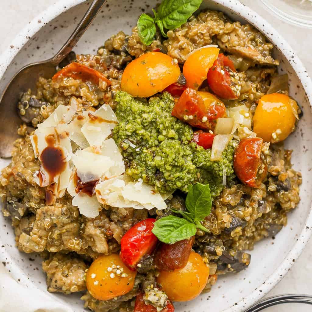 A bowl of risotto with tomatoes and pesto.