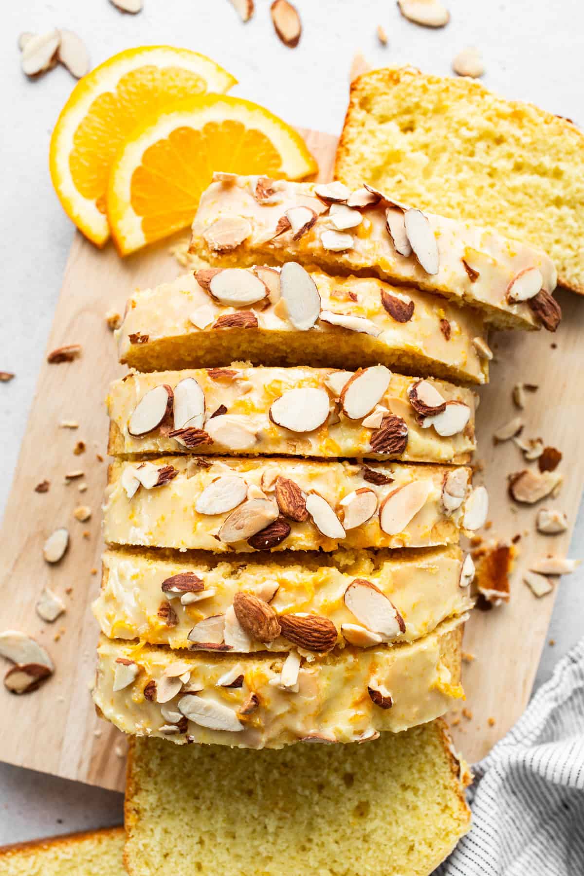 A slice of bread with almonds on a cutting board.