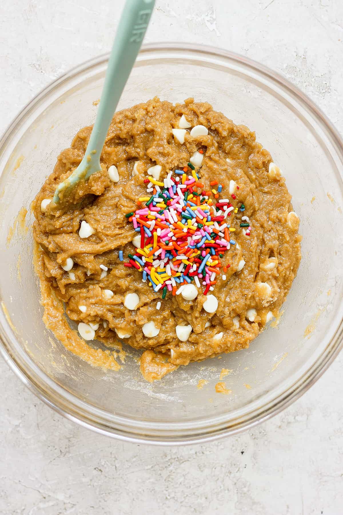 A bowl of brown dough with sprinkles.