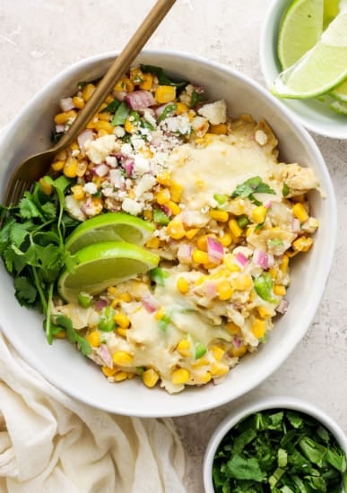 Mexican chicken and corn enchiladas in a white bowl.