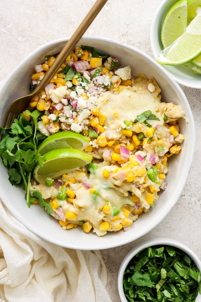Mexican chicken and corn enchiladas in a white bowl.