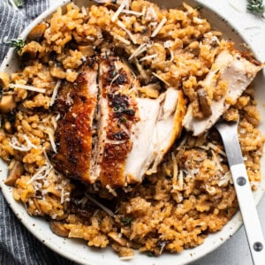 Chicken risotto with mushrooms and thyme on a plate.