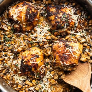 A pan with chicken and mushrooms in it.