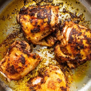 Roasted chicken in a skillet on a white background.