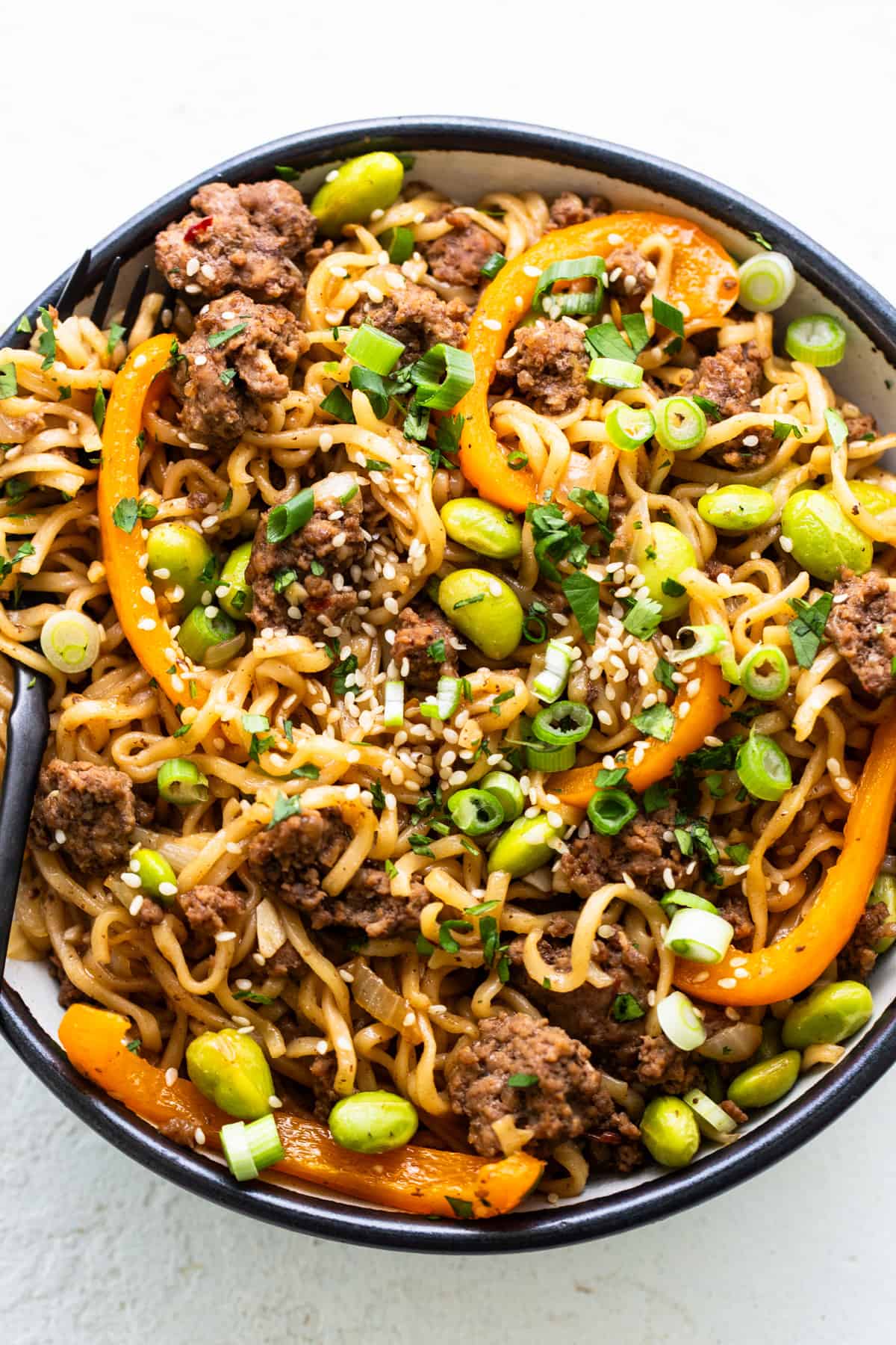 A bowl of noodles with meat and vegetables.