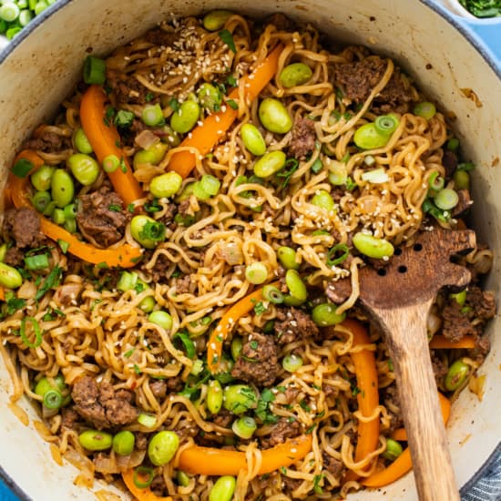 A bowl of noodles with meat and vegetables in it.