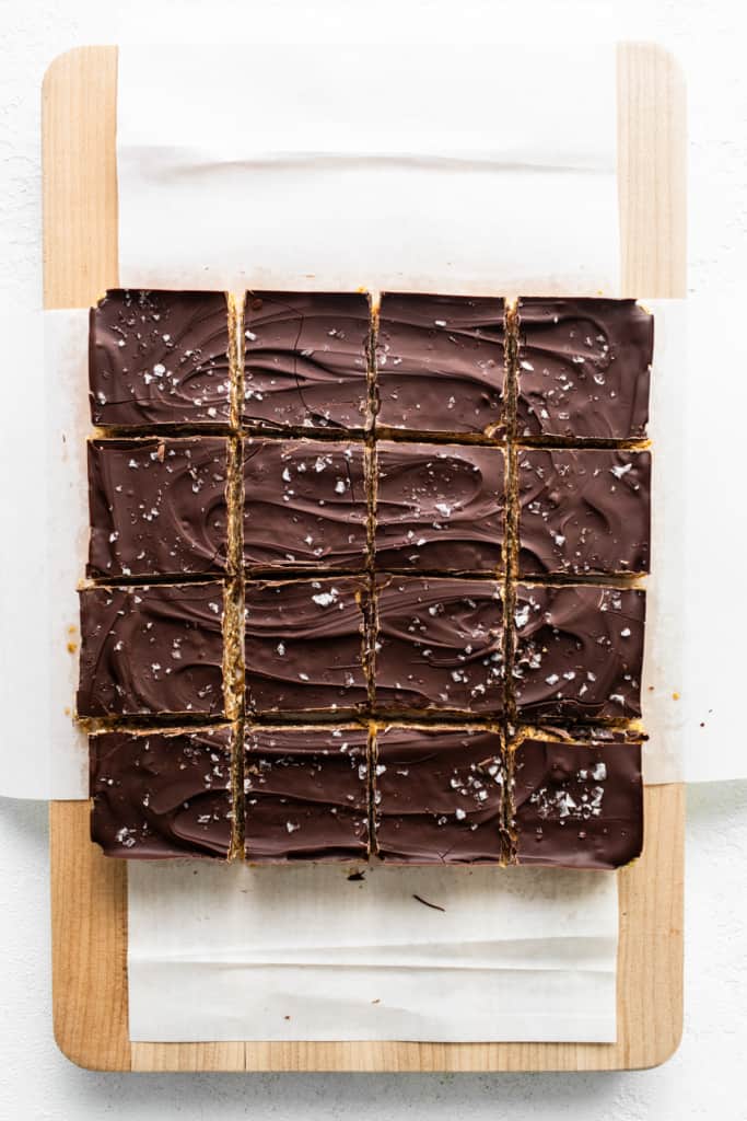 Squares of chocolate bars on a cutting board.