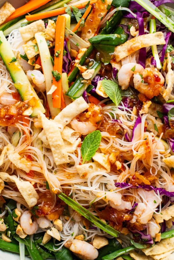 A bowl of asian noodle salad with shrimp and vegetables.
