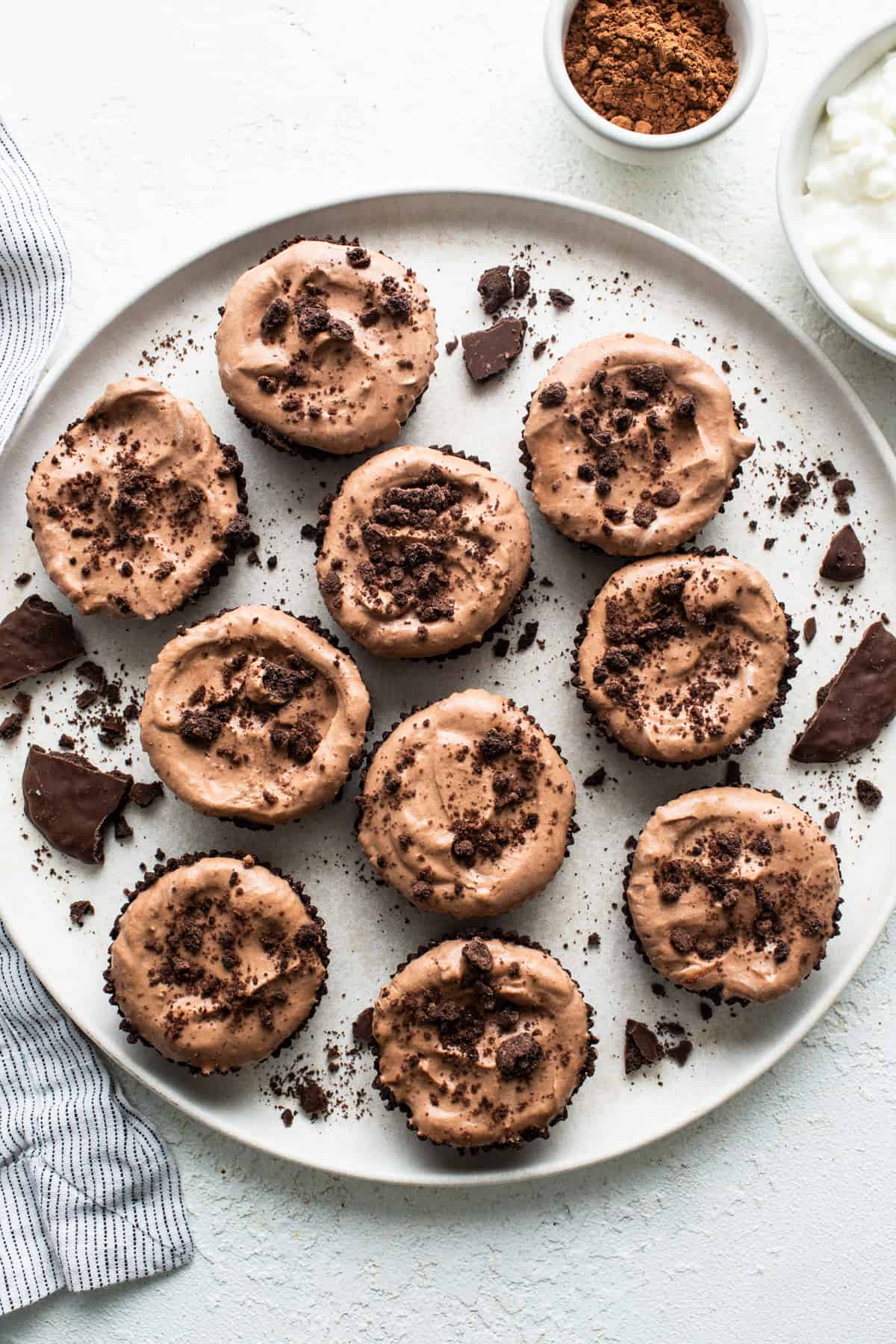 Chocolate cupcakes with chocolate frosting on a plate.