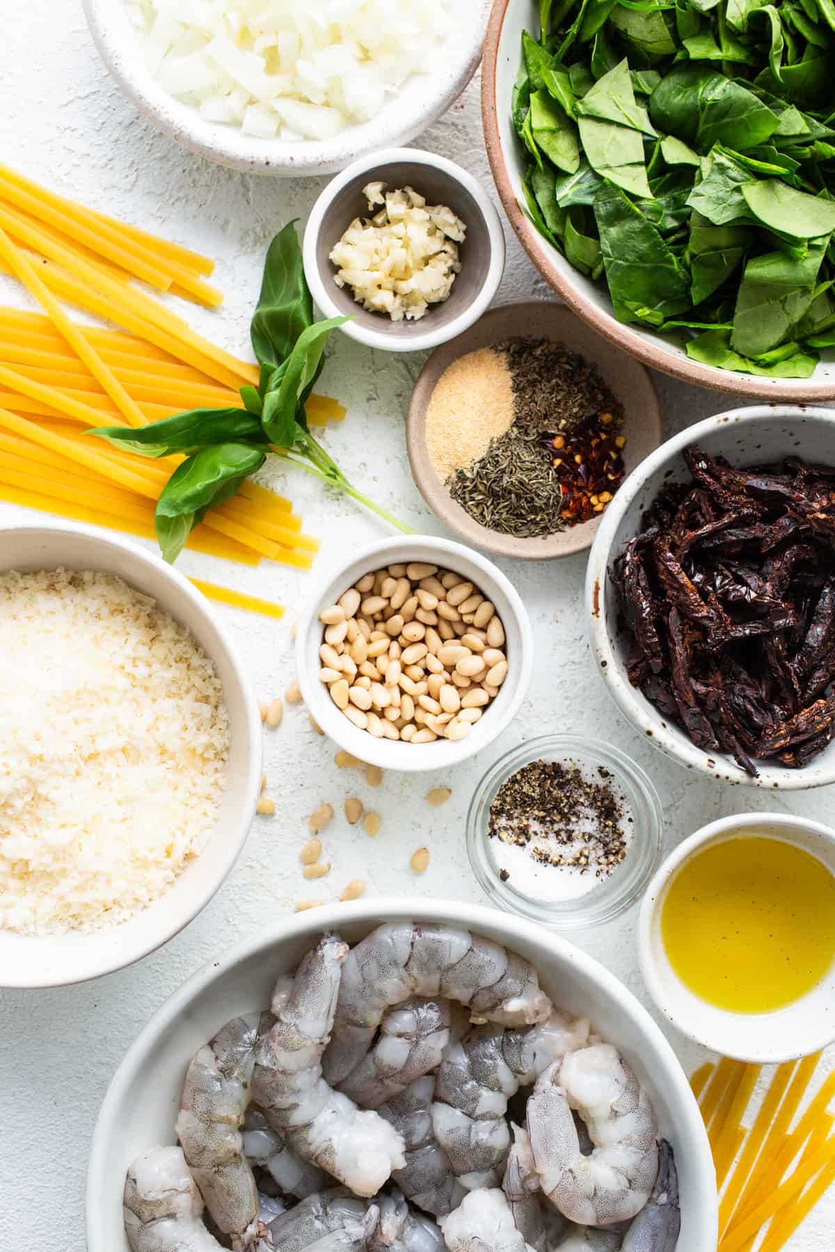 Ingredients for a pasta dish with shrimp and spinach.