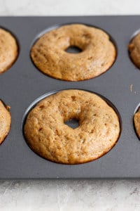 Freshly baked donuts in a non-stick baking pan.