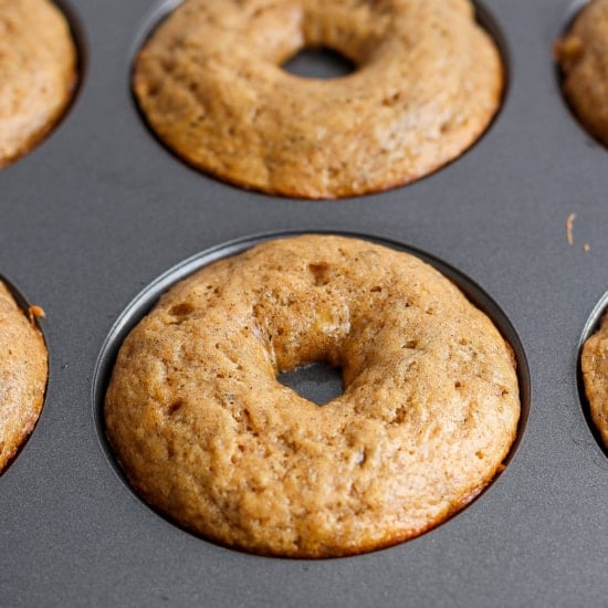 Freshly baked donuts in a non-stick baking pan.