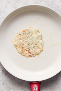 A single rice cake with scattered crumbs on a white plate.