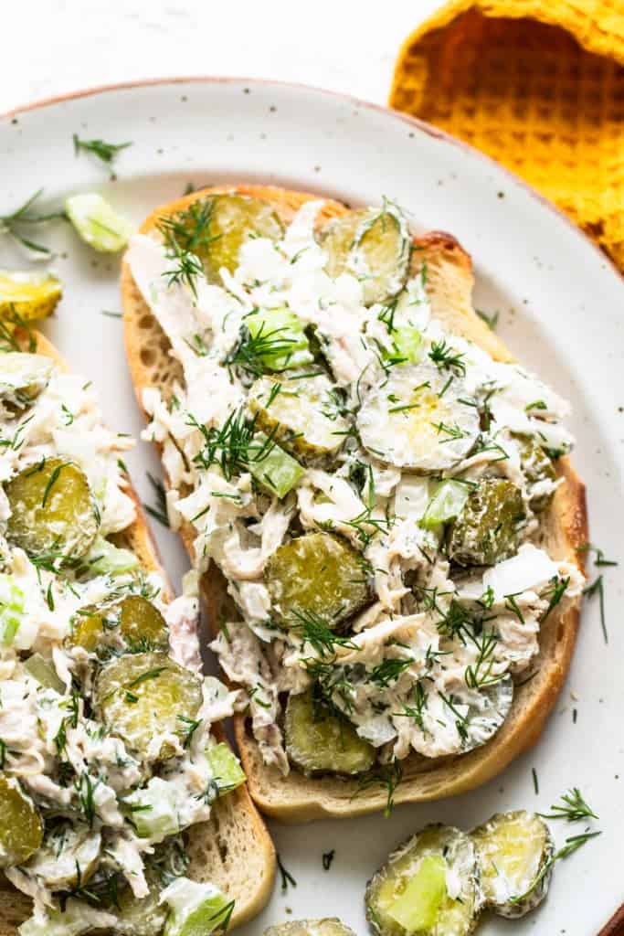 Chicken salad with pickles and dill on toasted bread.