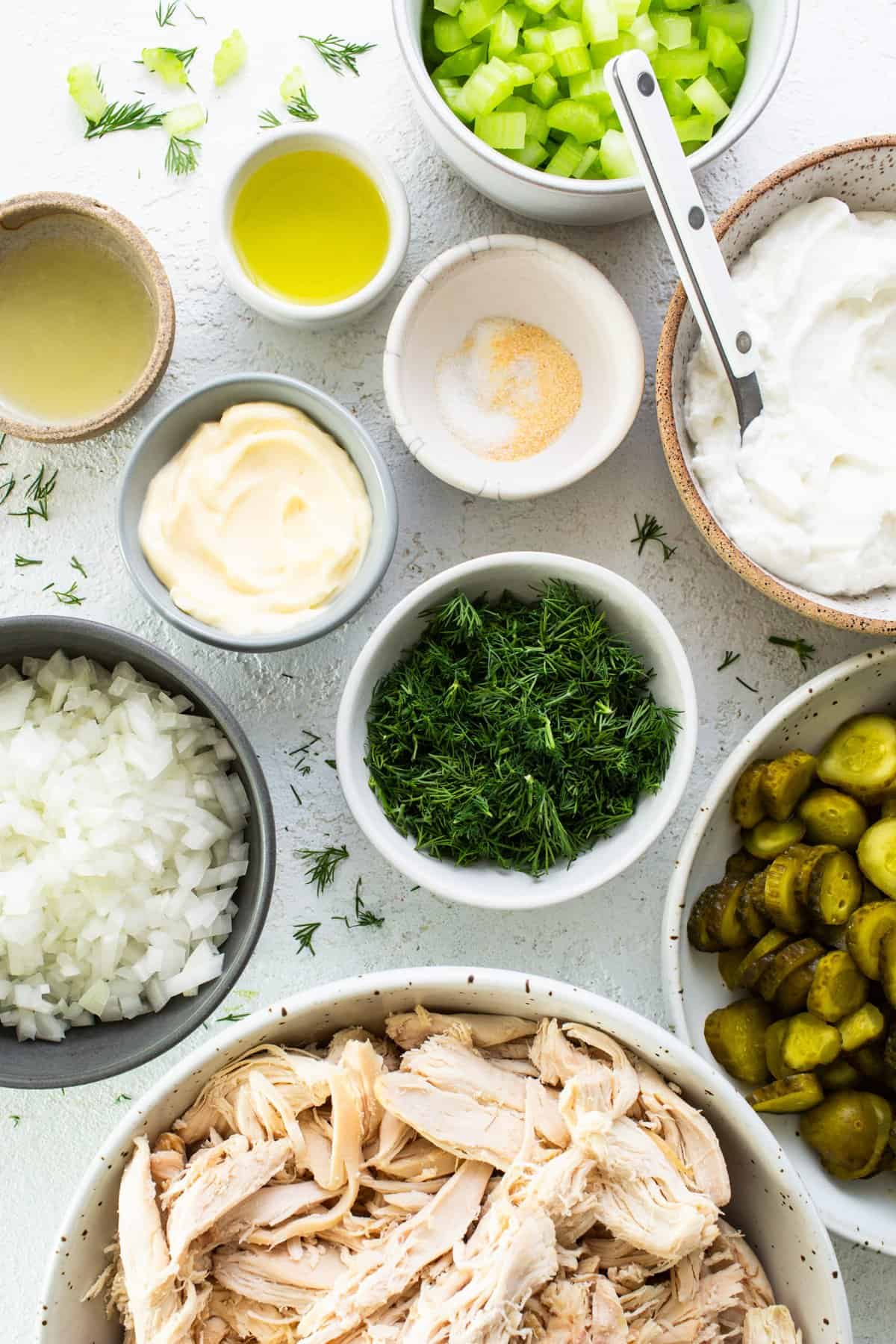 Various ingredients prepared for cooking, including chopped vegetables, shredded chicken, and condiments.