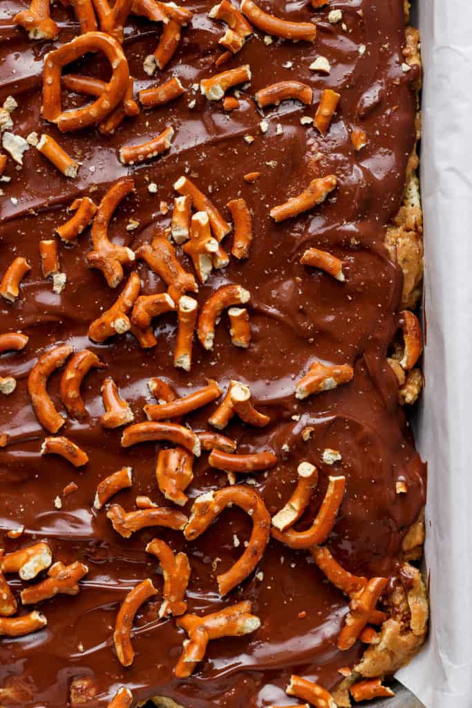 A tray of chocolate-covered toffee topped with pretzels.