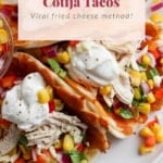 A plate of chicken cotija tacos garnished with a colorful corn salsa and a creamy sauce, highlighting a fried cheese method.