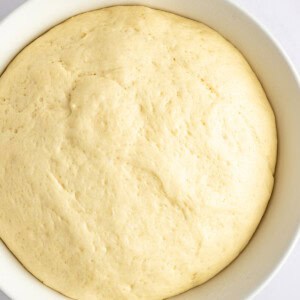 A close-up view of a bowl filled with risen dough.