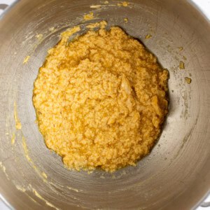 A metal bowl containing a yellow mixture is shown from above.