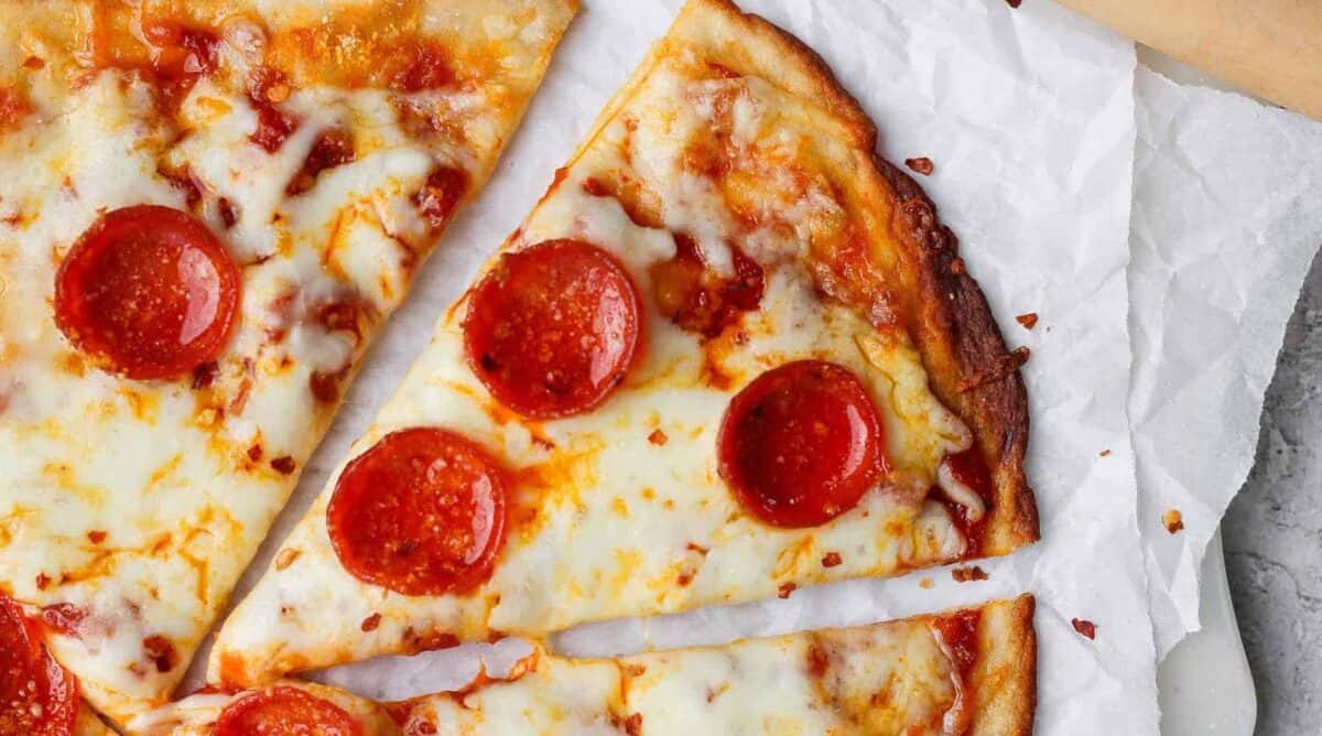 Slices of pepperoni pizza on parchment paper.