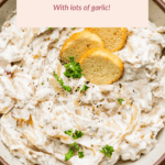 A bowl of caramelized onion dip garnished with fresh herbs and round crackers. A text overlay reads: "Caramelized Onion Dip With lots of garlic!.